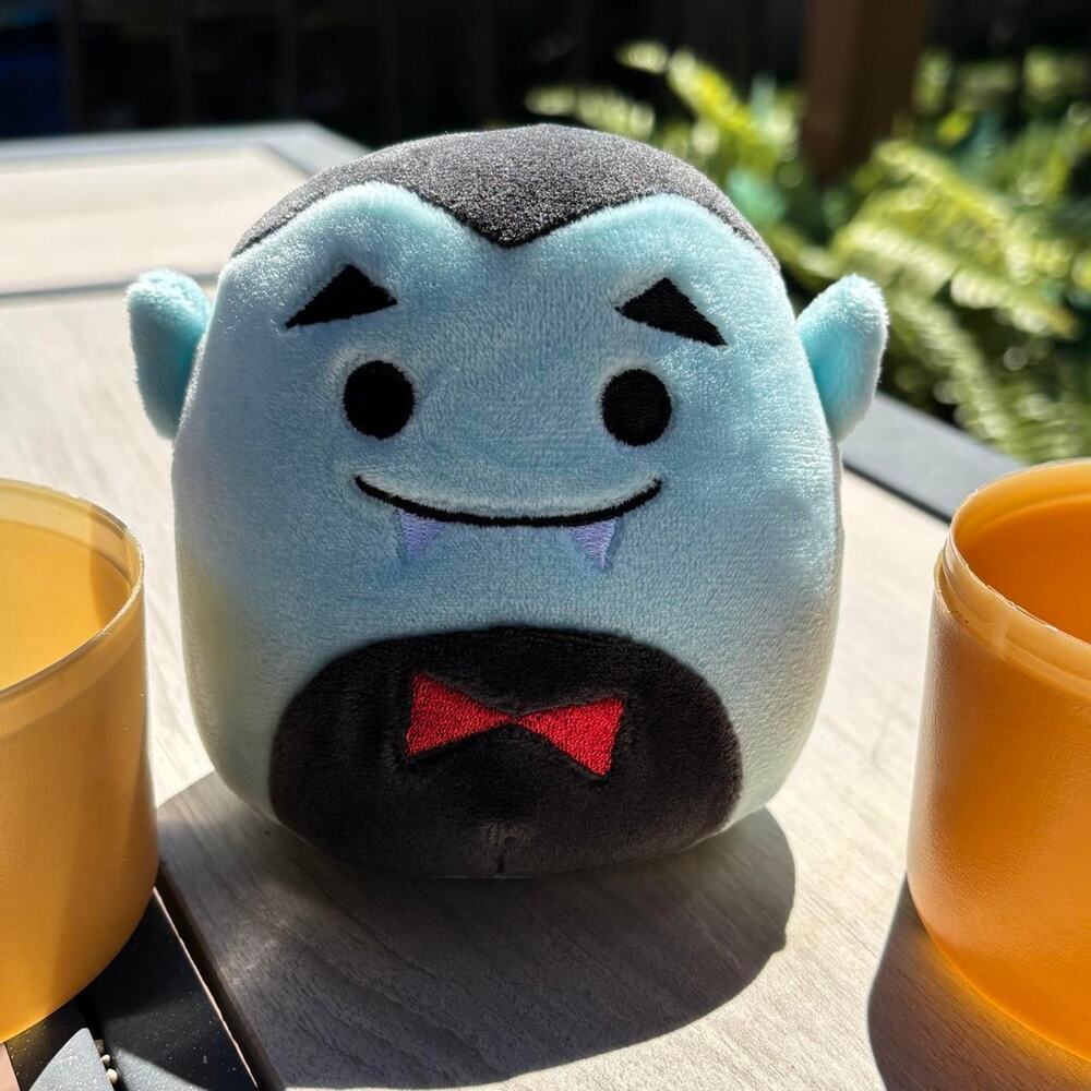 Squishmallows Drake the Vampire inside his capsule container.